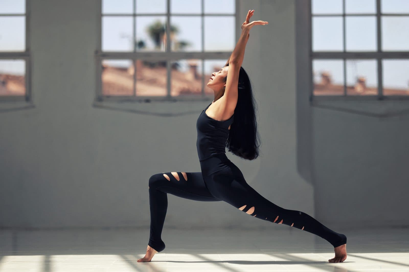 Wipa in a warrior reach pose in a yoga studio