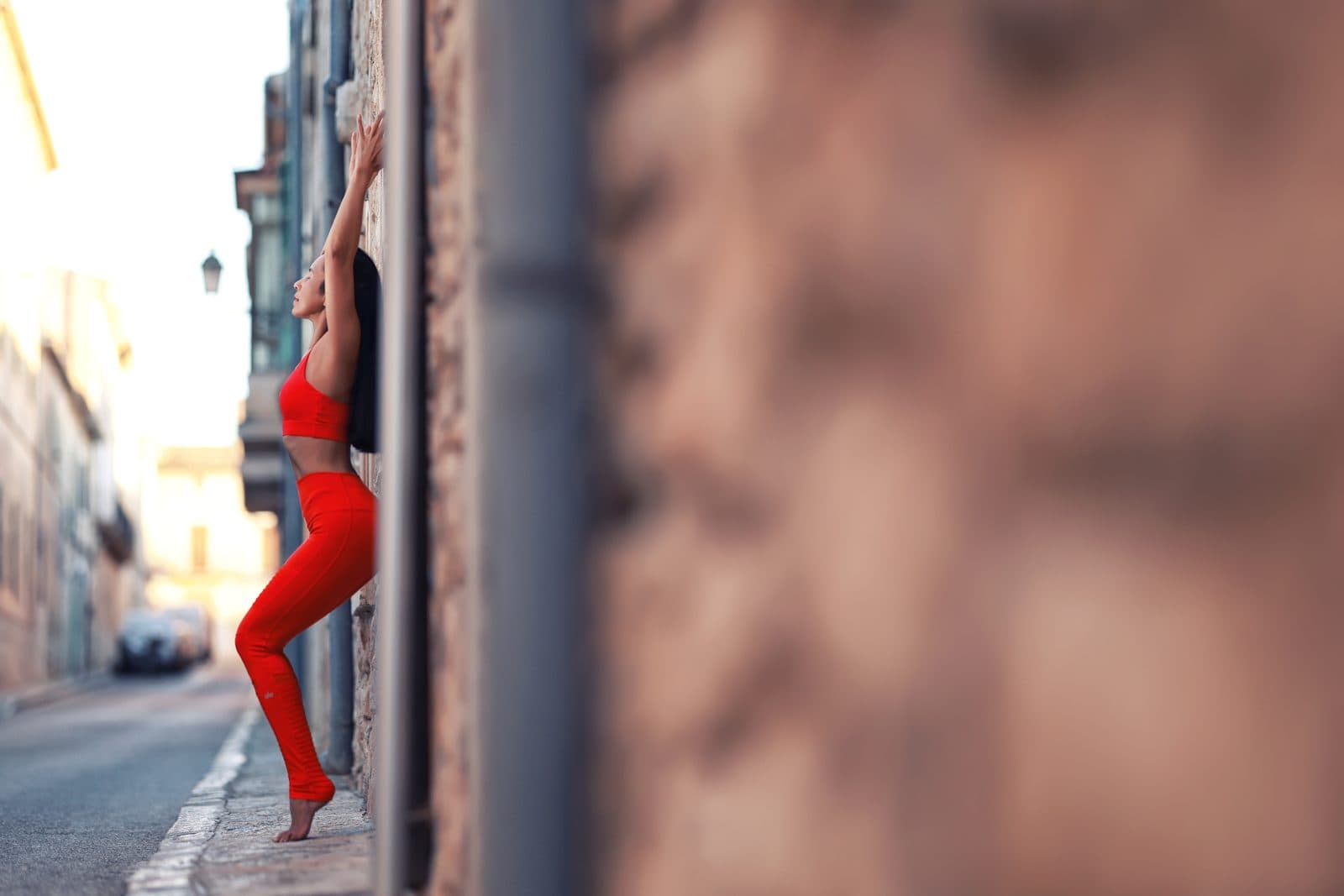 Wipa stretching against a wall on a city street