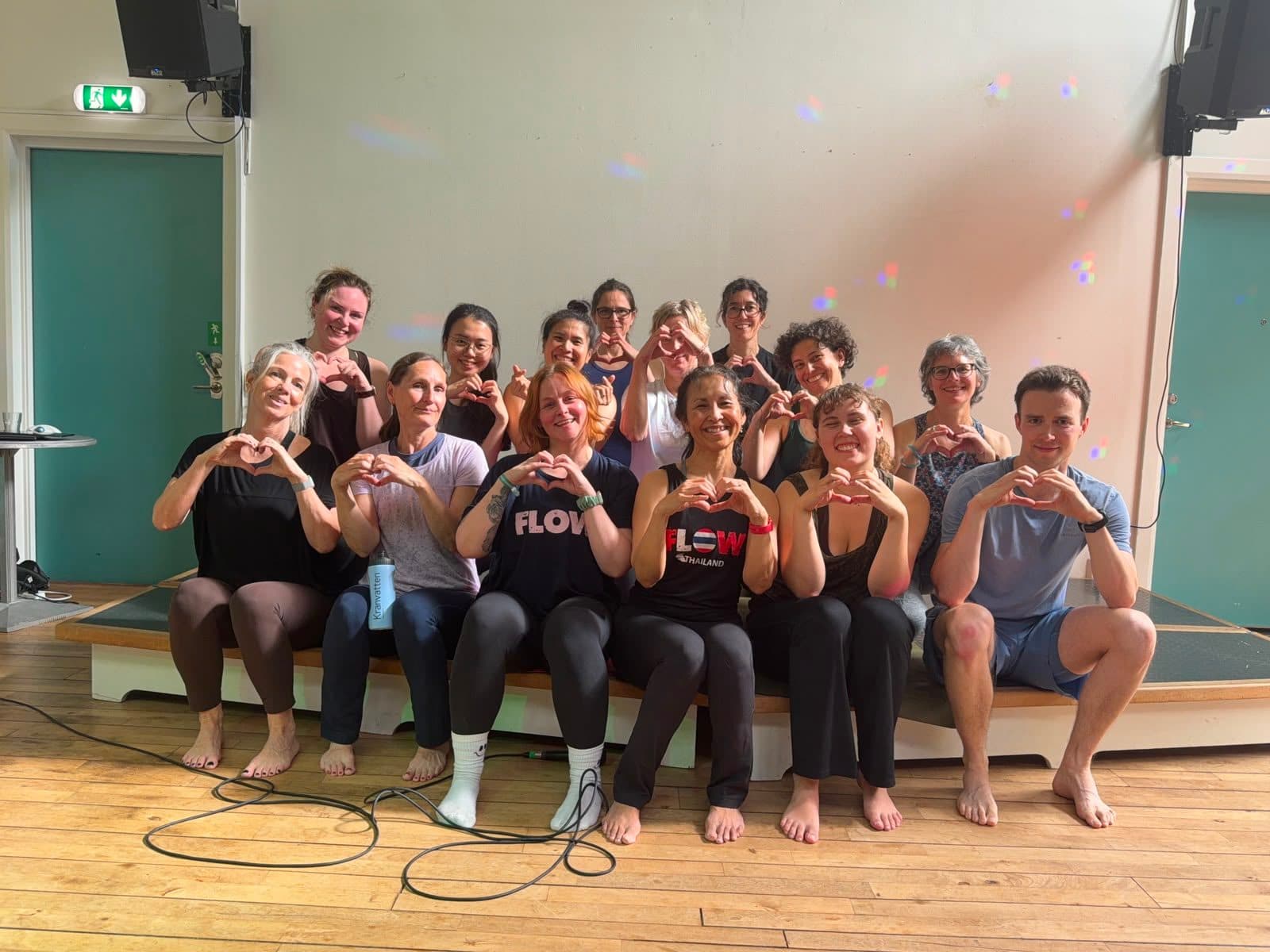 Participants from the last Inside Flow concert forming hearts with their hands